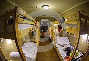 Three-level dormitory beds inside the hostel room for six tourists or students