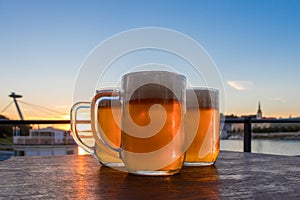 Three light beer glasses on the wooden table