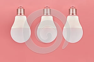 Three light bulbs, copy space. Energy saving minimal idea concept.Pink background
