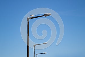 Three light poles with seagull standing on top