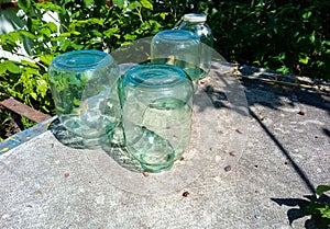 Three liter cans stand on a table in the garden