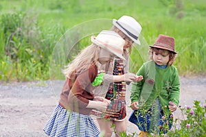 Three little adorable sisters girls exploring nature at the ranch together