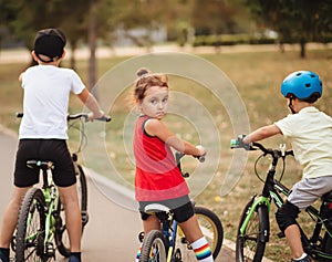 Three little cyclists riding their bikes and enjoy having fun. Kid outdoors sport summer activity