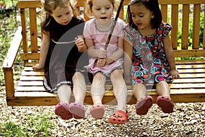 Three little girls on swing