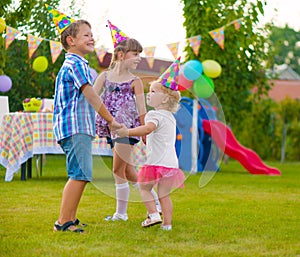 Three little kids dancing roundelay