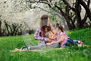 Three little sisters having a lot of fun playing together outdoor in summer park on vacation photo