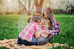 Three little sisters having a lot of fun playing together outdoor in summer park on vacation photo