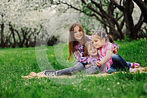 Three little sisters having a lot of fun playing together outdoor in summer park on vacation photo