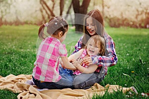 Three little sisters having a lot of fun playing together outdoor in summer park on vacation photo