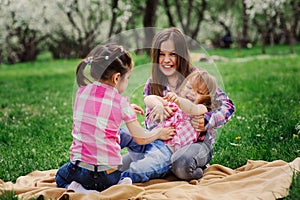 Three little sisters having a lot of fun playing together outdoor in summer park on vacation photo