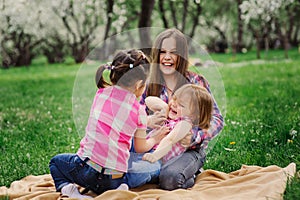 Three little sisters having a lot of fun playing together outdoor in summer park on vacation photo