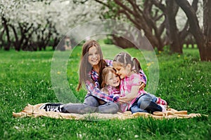 Three little sisters having a lot of fun playing together outdoor in summer park on vacation photo