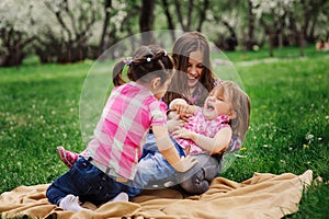 Three little sisters having a lot of fun playing together outdoor in summer park on vacation photo