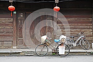 Three local bicycles in front of wooden door