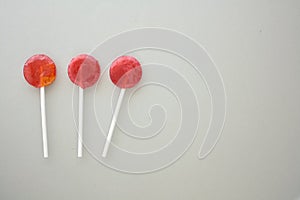 Three lollipops isolated on grey paper