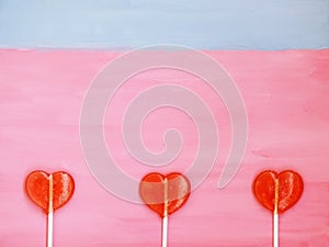 Three lollipops on pink and blue background