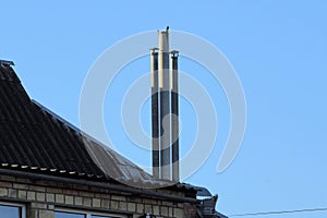Three long gray chimneys on the slate roof