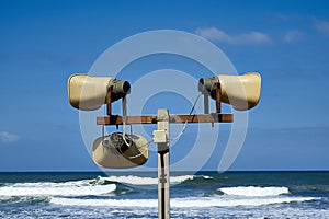 Three loudspeakers on a sea coast. Megaphone Attention.