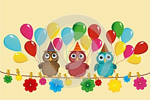 Three lovely owls sit on a rope and hold balloons.