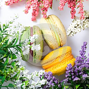 Three macarons on the table around flowers, the atmosphere of romance and tenderness, Valentine`s Day, Mother`s Day, Spring Day