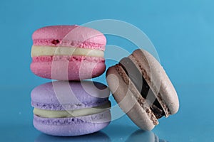 Three macaroons lie triangle on a blue background with a place for text and copyspace