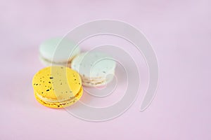 Three macaroons on pink background yellow and white, french dessert, easter gift