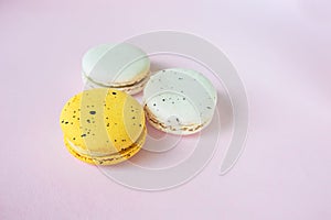 Three macaroons on pink background yellow and white, french dessert, easter gift