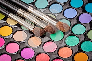 Three makeup brushes on makeup palette
