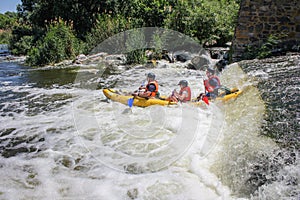 Three man white water kayaking on the river, extreme and fun sport at tourist attraction.