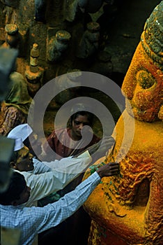 Three man and A woman devotee paying her respects to lord Khandoba at the Jejuri temple , Pune