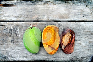 Three mango, green, yellow, red like reggae color on wood table background.