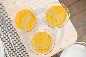 Three mango mousses in glass bowls photo