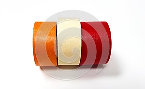 Three masking tapes roll red, white, and orange isolated on white background.