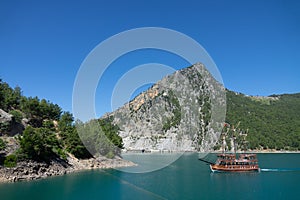 A three-masted tourist yacht sails on the lake near the Oymapinar dam. Green canyon, Manavgat, Antalya, Turkey