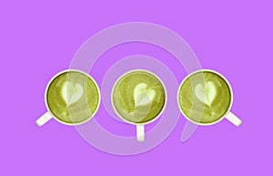 Three of Matcha Green Tea with Heart Shaped Latte Art Rowed Up on Purple Background