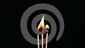 Three Matchsticks Ignites and Burns on a Black Background Close-Up