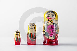 Three matryoshkas in a row lined up for growth on a light isolated background