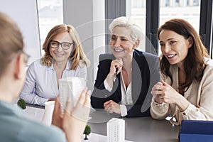 Three mature businesswomen having a conversation at conference table
