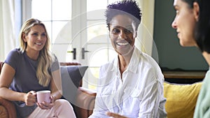 Three Mature Female Friends In Lounge At Home Meeting For A Chat And Hot Drink