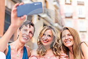 Three mature female friends taking a selfie in the city