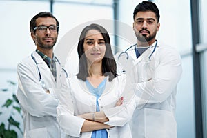 Three medical colleagues stand in the lobby of the hospital