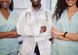 Three medical healthcare professionals stand in a row arms folded - Cropped