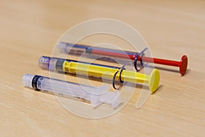 Three Medical Syringes of Different Colors and Size