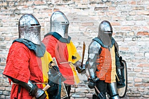 Three medieval knights in armor. In red