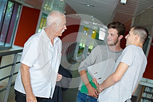 Three men having conversation on hallway