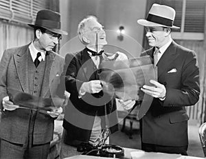 Three men looking at x-rays