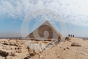 three men walking towards Keops\' pyramid. El Cairo Egypt