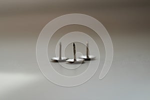 Metal thumb tacks on white background