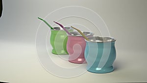 Three metallic mates with tube for sipping on a white shaded background