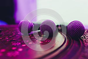 three Microphones in group on red table with copy space.